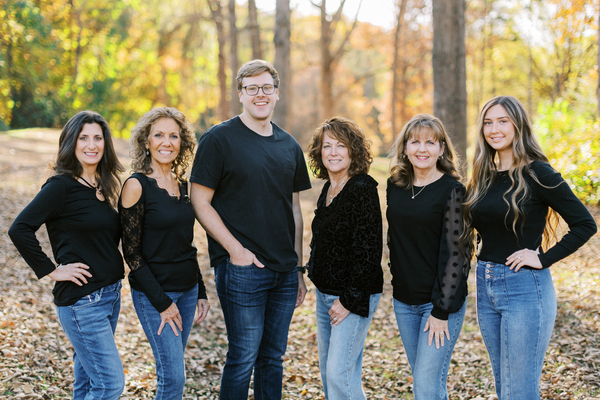 The Hickory Dentist team by Dental Health Concepts dressed in black shirts and blue jeans while standing in the woods.